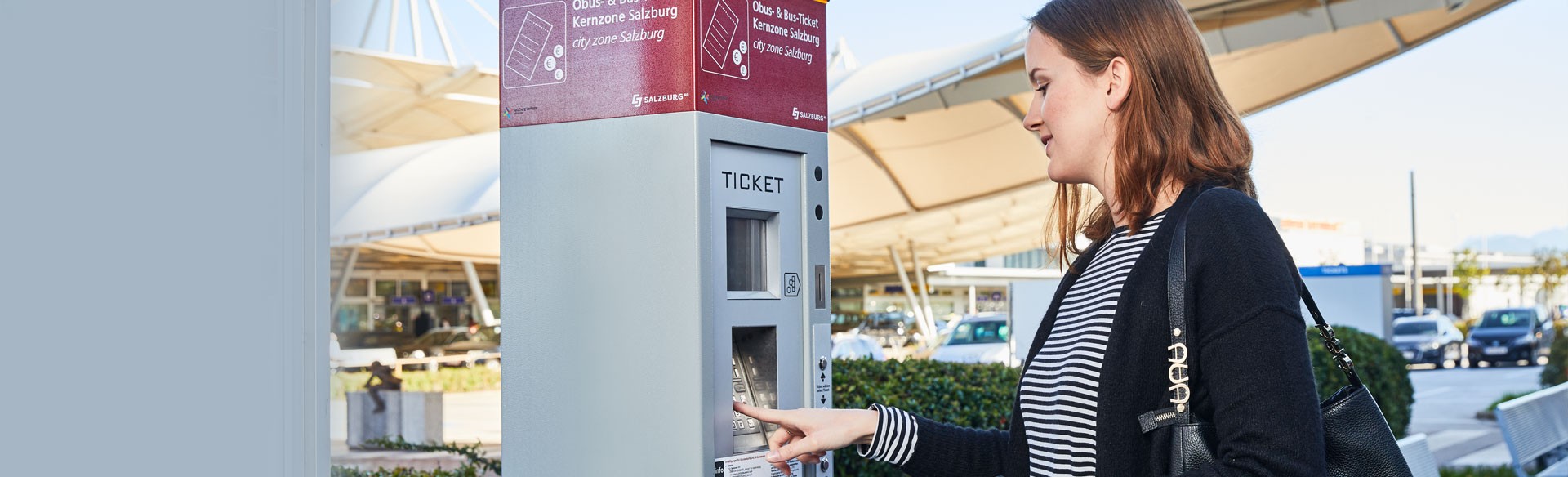 Frau kauft Ticket am Automaten in Salzburg.