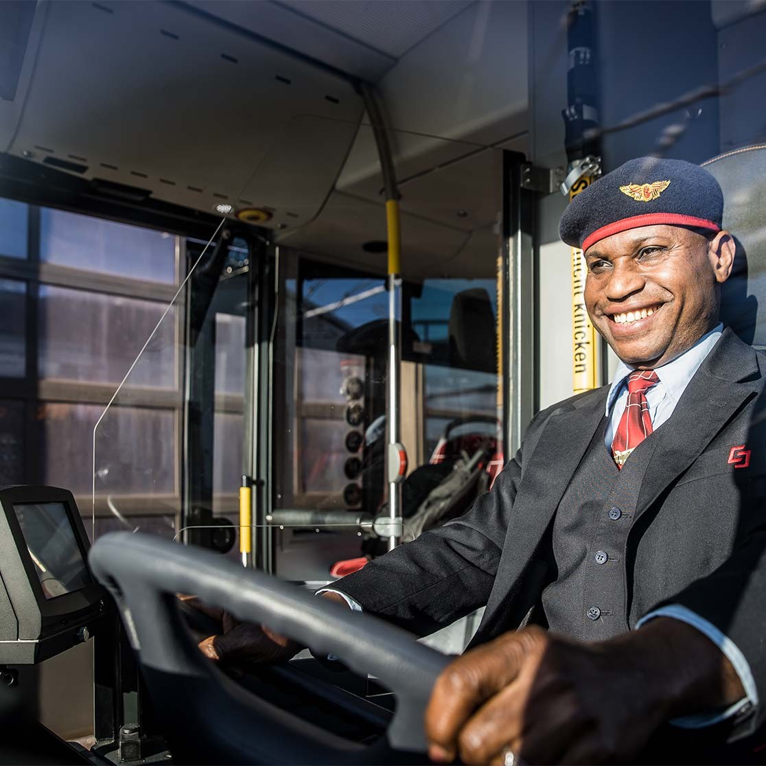 Lenker der Salzburg Linien in Uniform sitzt am Steuer eines Obusses