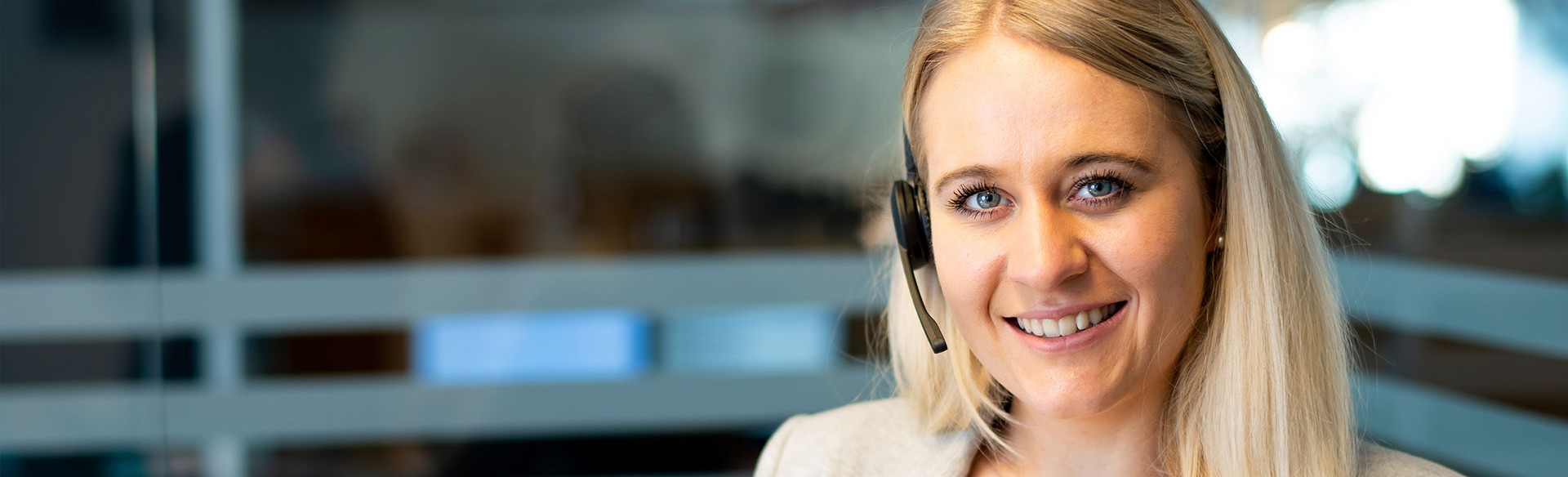 Lächelnde Kundenservice-Mitarbeiterin mit Headset