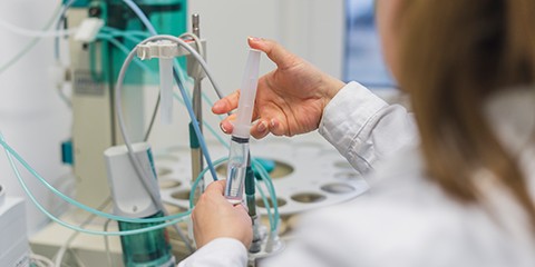 Laborantin füllt Spritze in Labor.