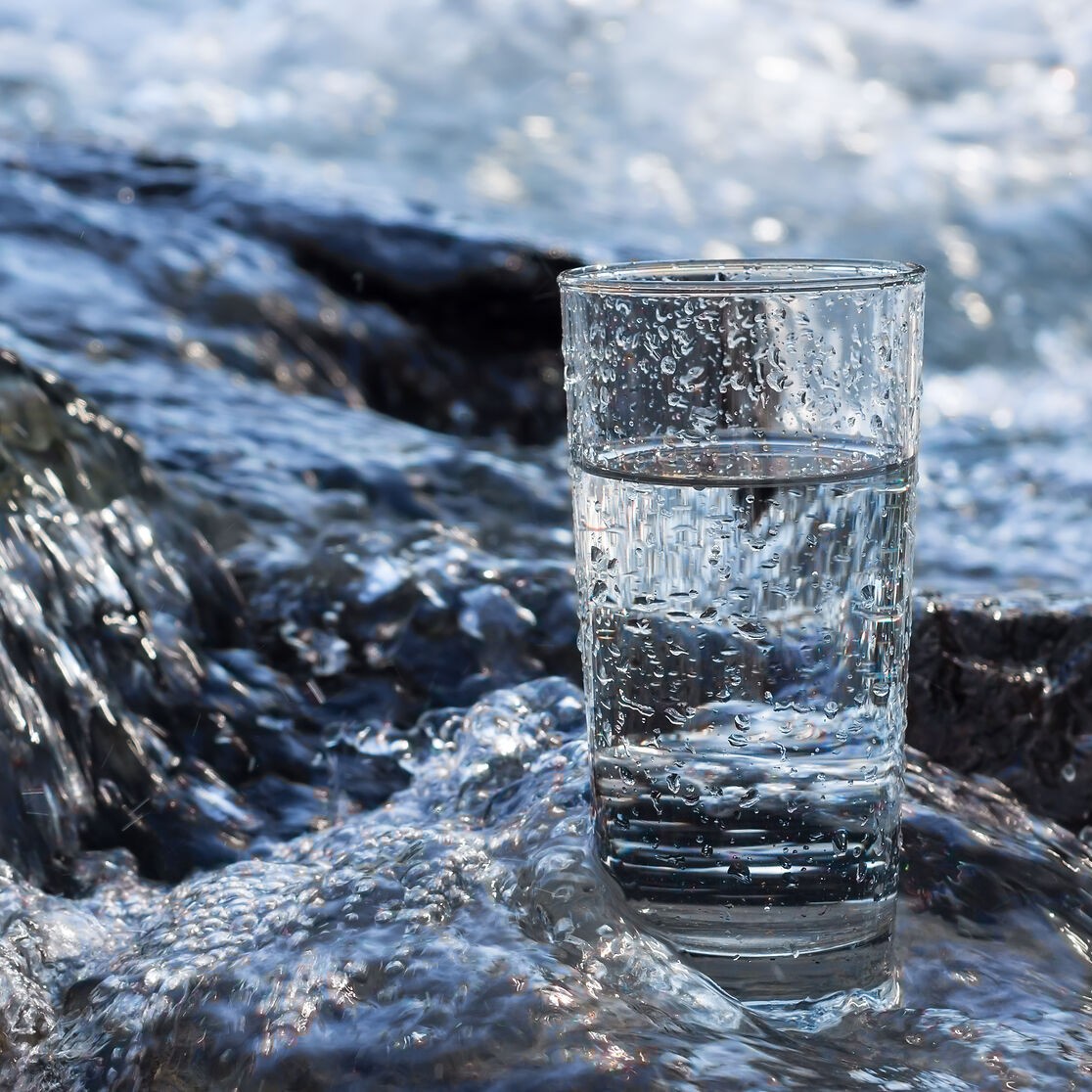 Gefülltes Wasserglas steht im Fluss