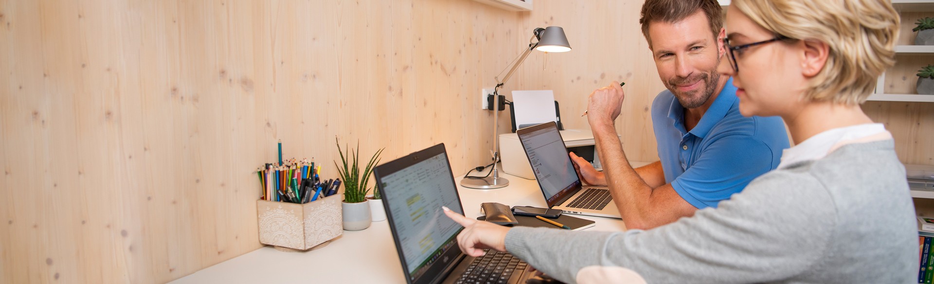 Mann und Frau arbeiten gemeinsam an Laptops.