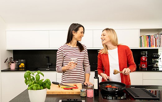 Zwei Frauen kochen gemeinsam in moderner Küche.
